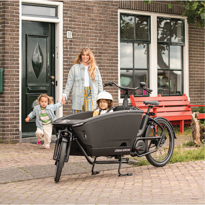 maman et ses 2 enfants devant un urban arrow familynext